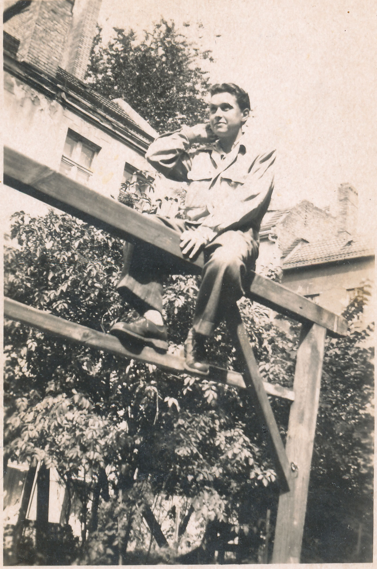 Einzelporträt von Rita Thomas alias Tommy auf einer Teppichstange im Hof, im Hintergrund Wohnhäuser