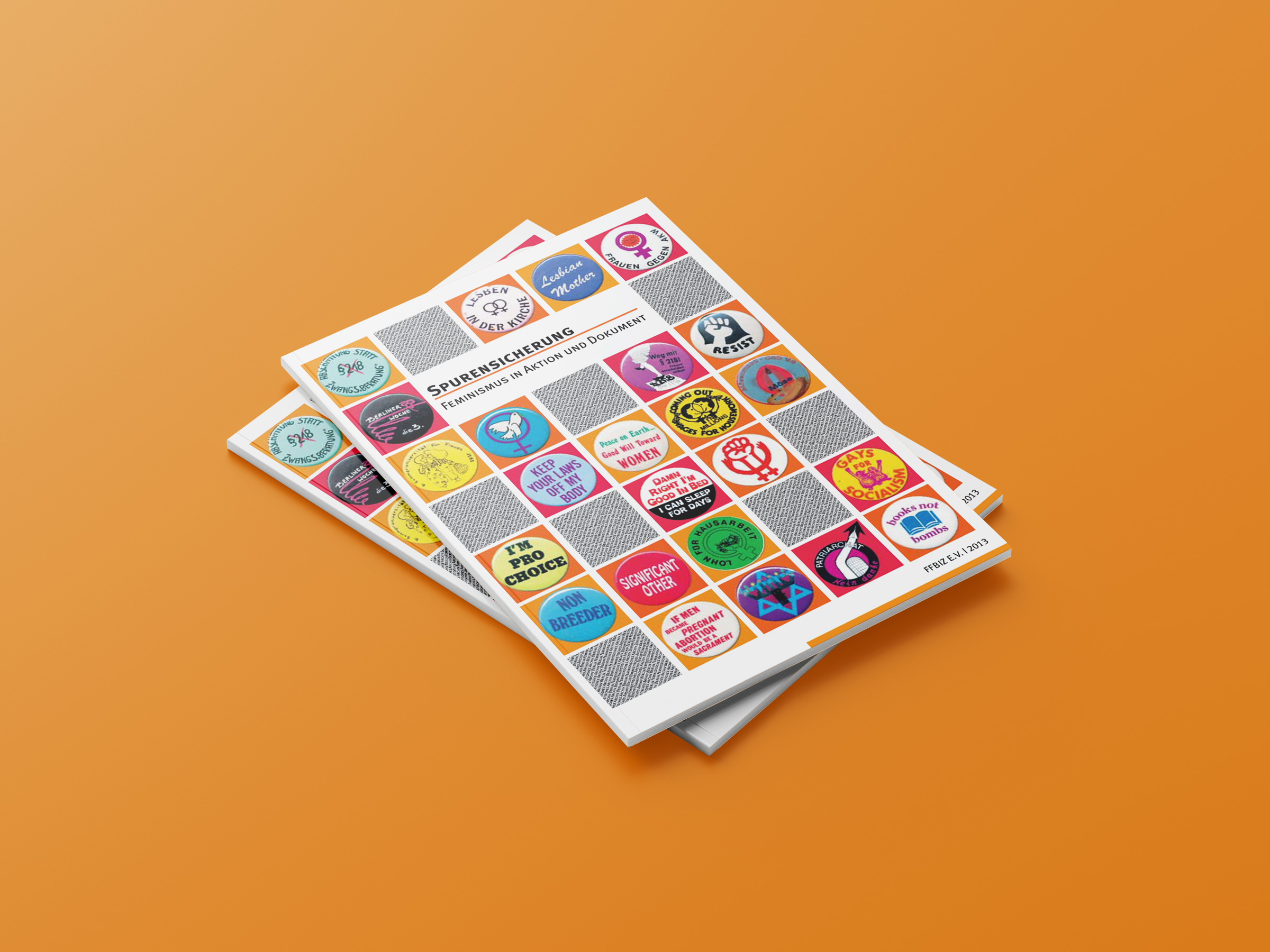 zwei Ausgaben der Publikation Spurensicherung liegen übereinander vor orangefarbenem Hintergrund; das Cover zeigt diverse farbige Button und Sticker
