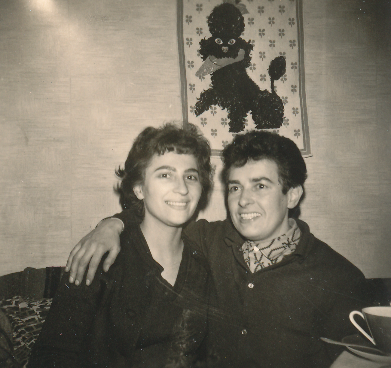 Paarfoto von Tommy und ihrer Freundin. Sie sitzen auf dem Sofa und Tommy hat ihren Arm auf ihre Schulter gelegt.